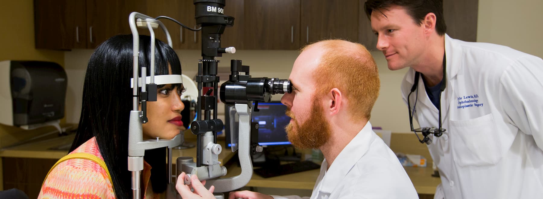 Two ophthalmologists examine a patient